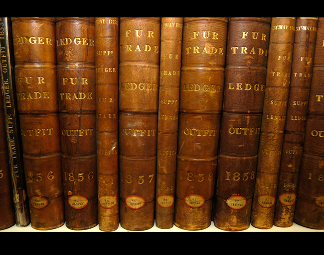 several Fur Trade Ledger books on a self